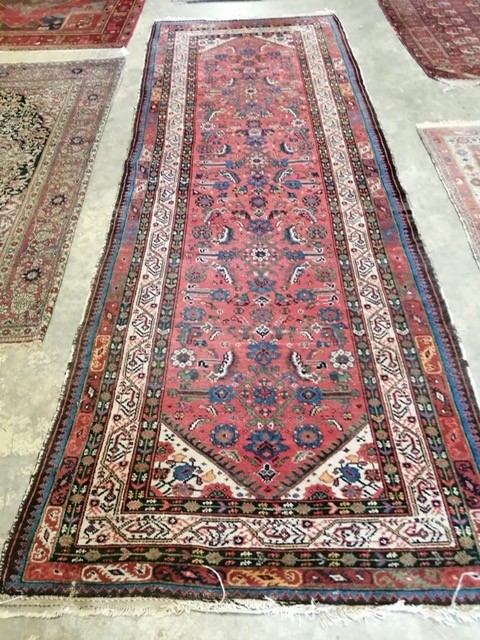 A Persian red ground runner, with central floral motifs, multi-bordered 330 x 123cm